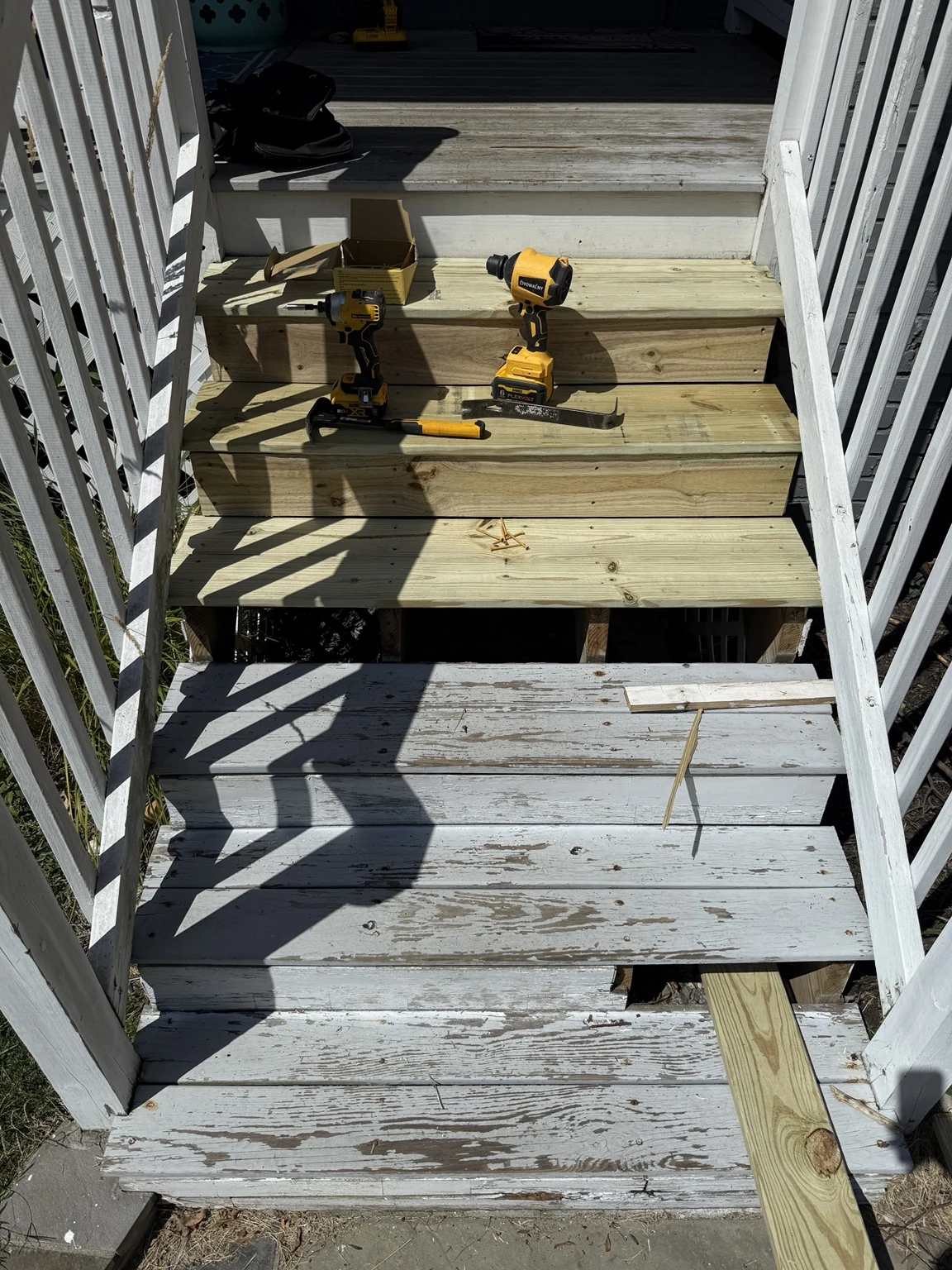 Exterior stair rebuild in progress with deteriorated painted treads being replaced