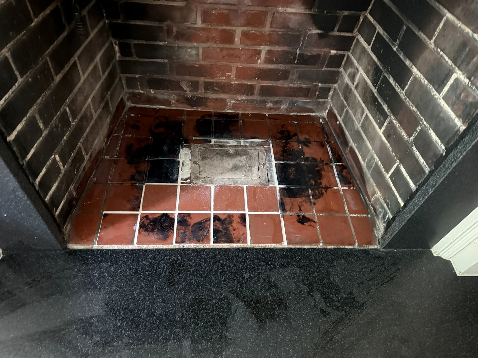Original fireplace hearth showing damaged Italian tile before restoration