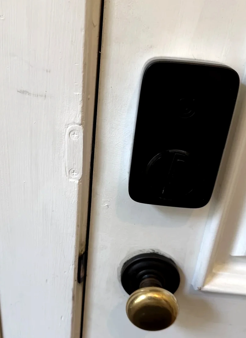 Black smart lock with custom fabricated door protection piece